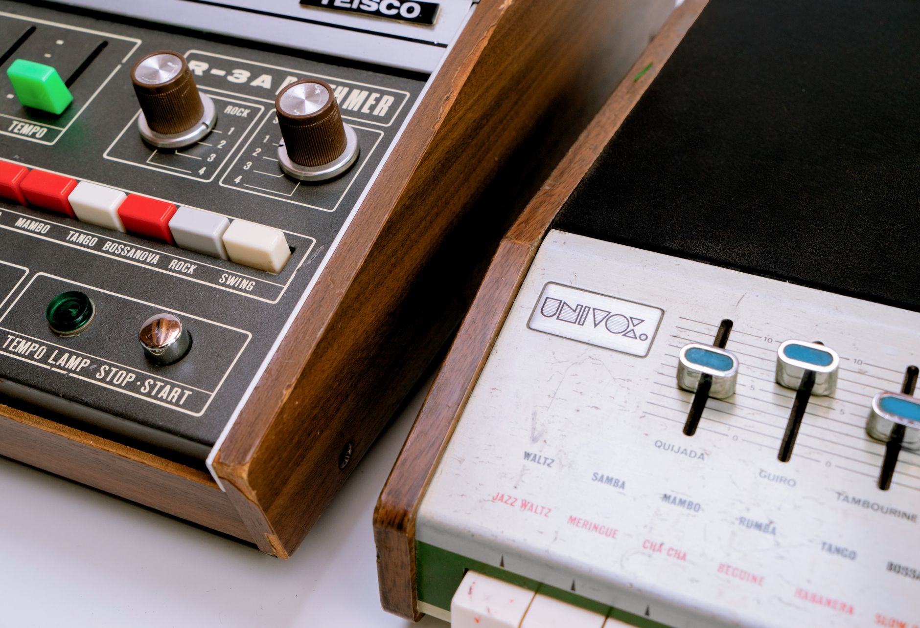 Close-up of vintage synthesizer and drum machine with wood accents, showcasing retro audio equipment.